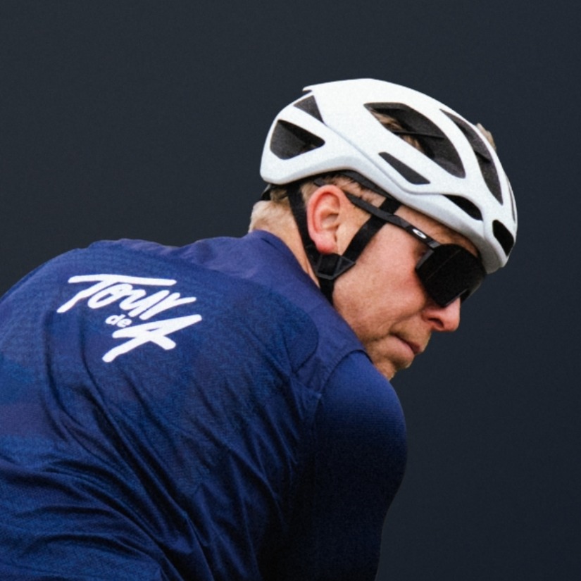 克里斯-霍伊身着环湖赛四强衫骑车，回头看着镜头